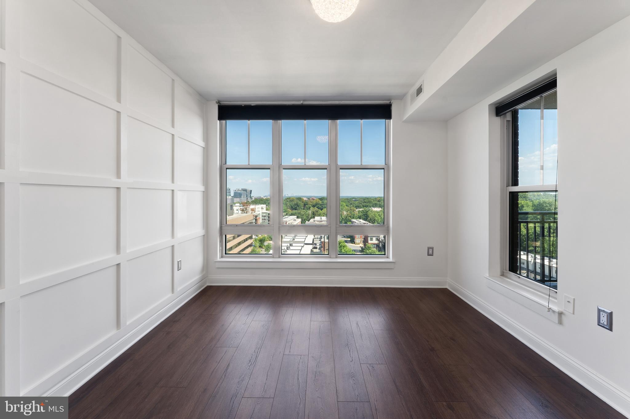 11760 Sunrise Valley Drive, Unit 809 Reston, VA 20191 - Photo 4 of 13 an empty room with wooden floor and windows
