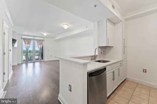 a kitchen that has a sink a stove and wooden floor