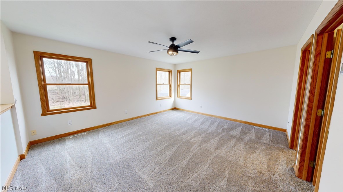 15548 Trask Road Thompson, OH 44086 - Photo 19 of 31 Master bedroom featuring light carpet, a healthy amount of sunlight, and ceiling fan