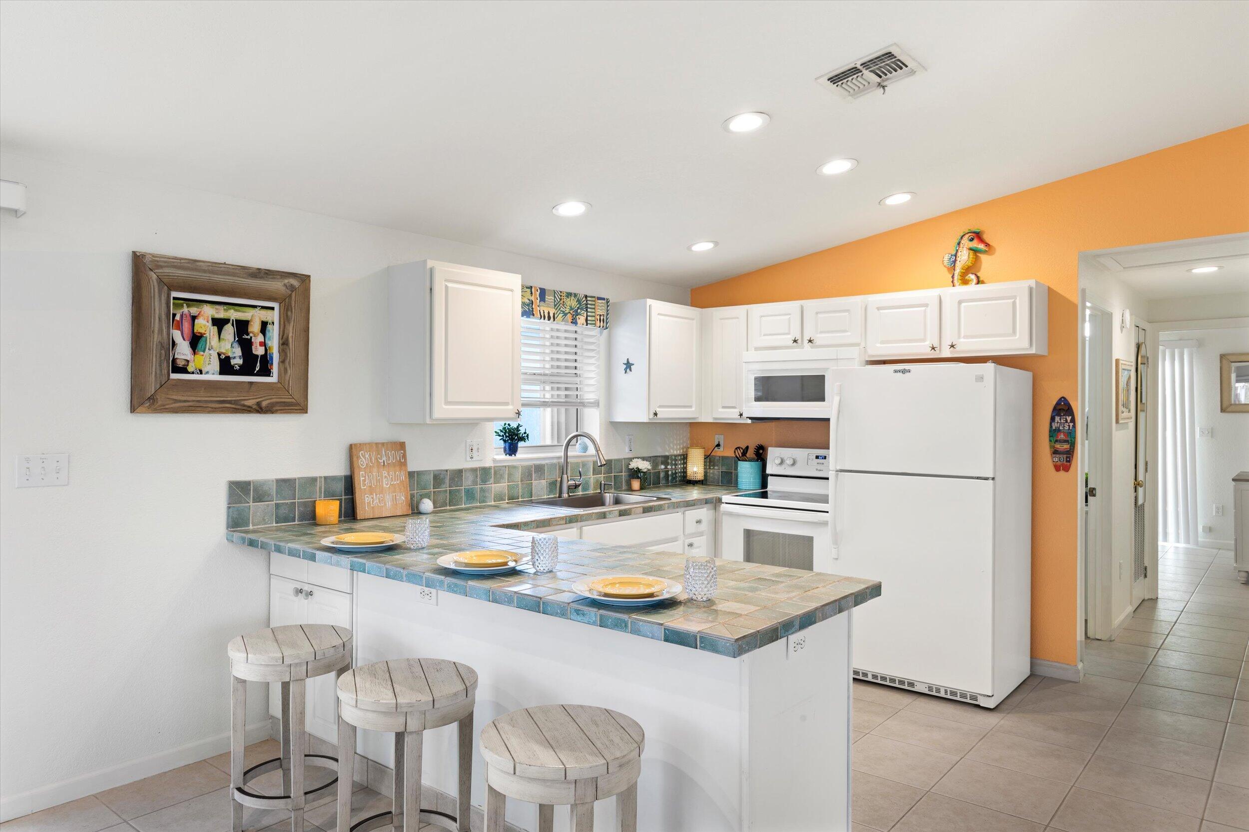 157 Mars Lane Key West, FL 33040 - Photo 16 of 41 a kitchen with a refrigerator a stove and a dining table