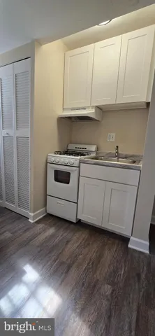 a kitchen with granite countertop a sink and a stove top oven