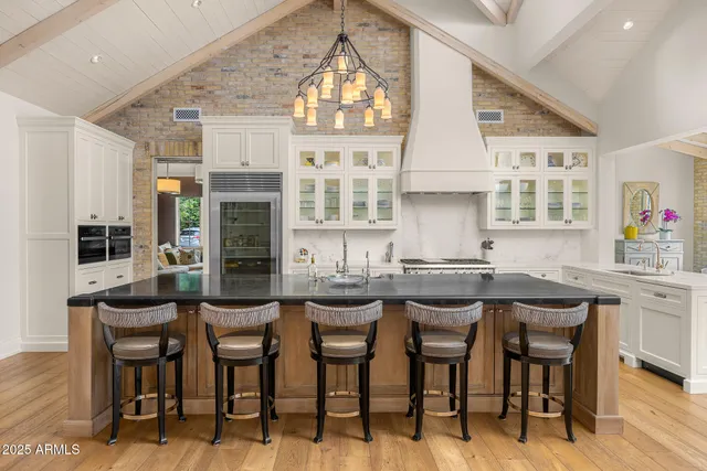 a view of a kitchen with stainless steel appliances granite countertop a sink and cabinets