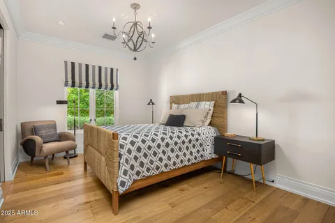 a bedroom with a bed and a chandelier