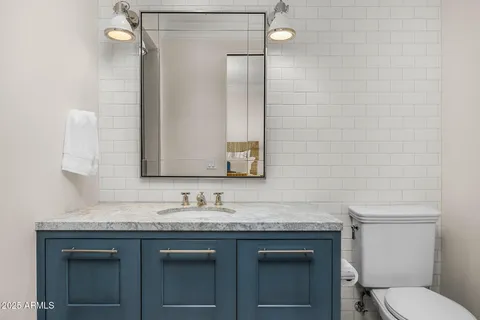 a bathroom with a granite countertop sink and a mirror