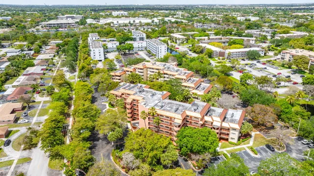 an aerial view of residential houses with outdoor space and trees