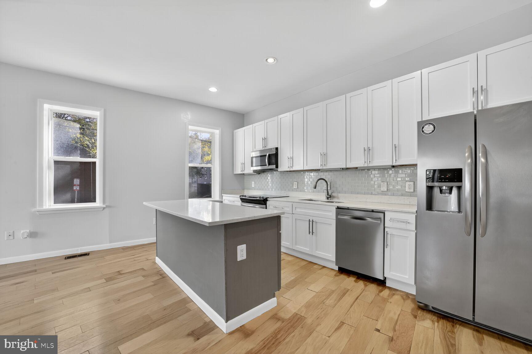 15 S Street Northeast, Unit 1 Washington, DC 20002 - Photo 2 of 12 a kitchen with stainless steel appliances granite countertop a stove top oven a refrigerator a sink and dishwasher with wooden floor