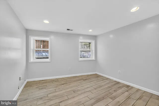 a view of empty room with wooden floor