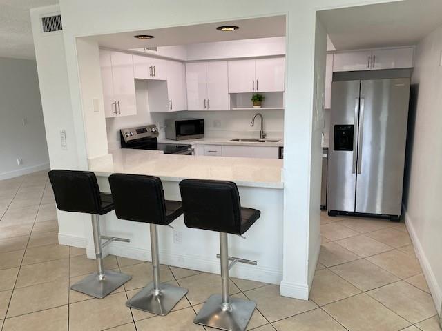 a kitchen with stainless steel appliances a stove a refrigerator and a view of dining table