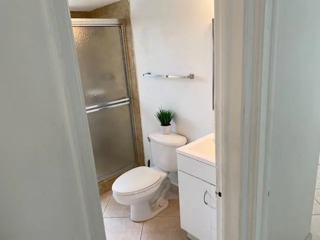 a white toilet sitting next to a shower