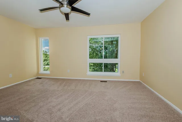 an empty room with windows and closet
