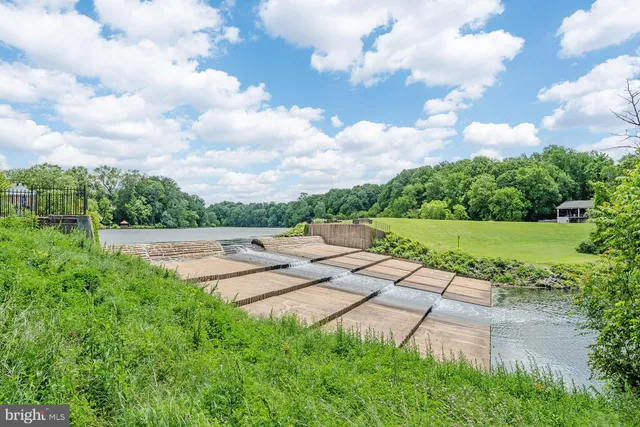 a backyard of a house with lots of green space and lake view