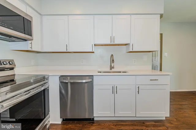 a kitchen with stainless steel appliances granite countertop a sink a stove and a microwave