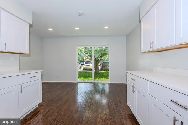 a view of a kitchen with wooden floor and electronic appliances
