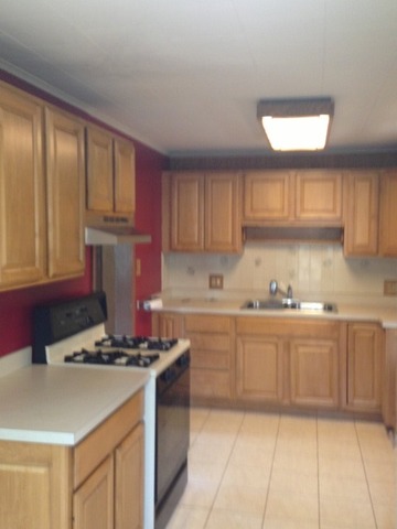 1-n063 Ridgeland Avenue West Chicago, IL 60185 - Photo 14 of 25 a kitchen with kitchen island granite countertop a sink cabinets and window