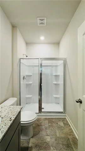 a bathroom with a granite countertop sink a toilet and shower