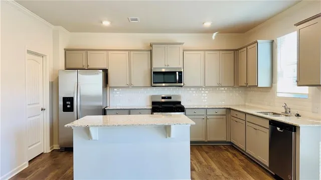 a kitchen with stainless steel appliances a refrigerator stove microwave and sink