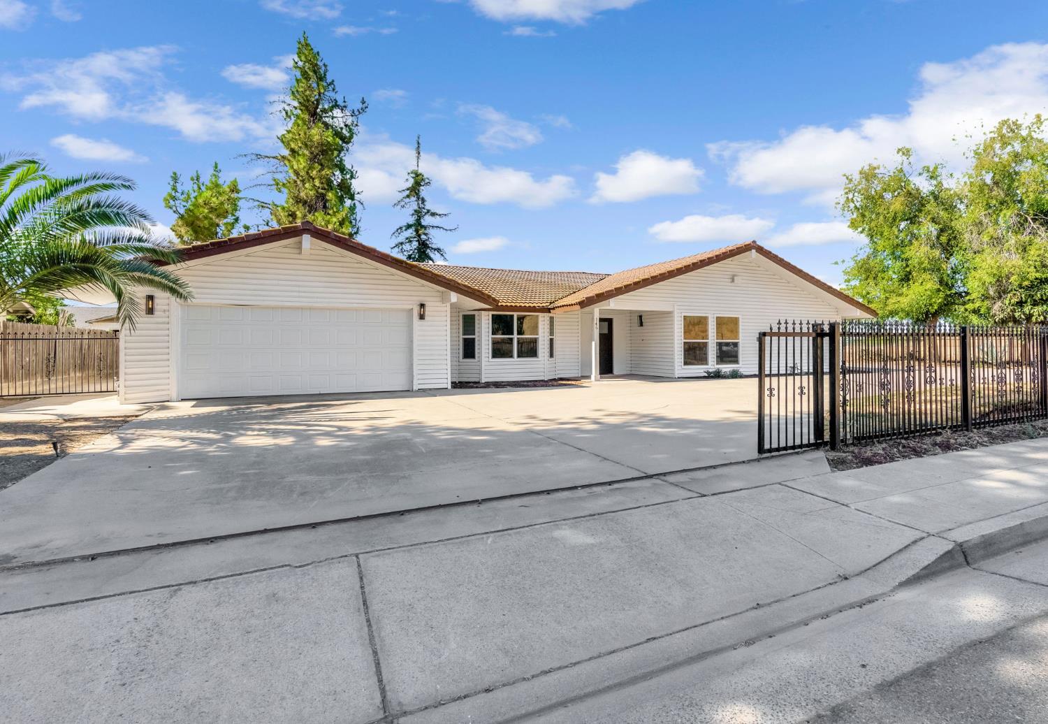 a view of house that has a small yard and large trees
