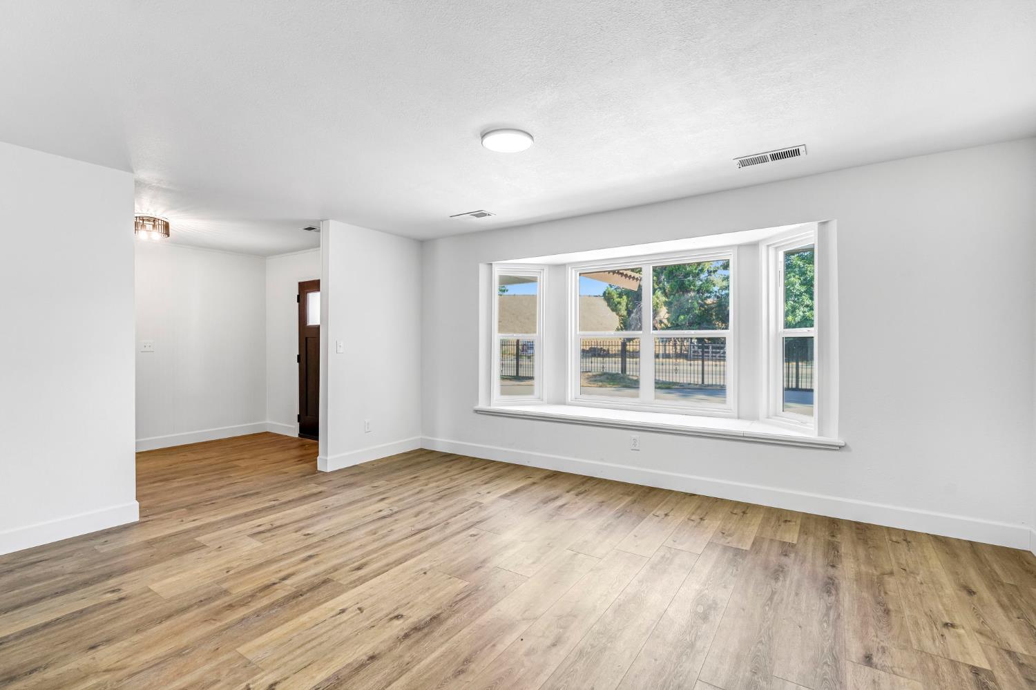146 Sierra Avenue Clovis, CA 93612 - Photo 22 of 45 a view of an empty room with wooden floor and a window
