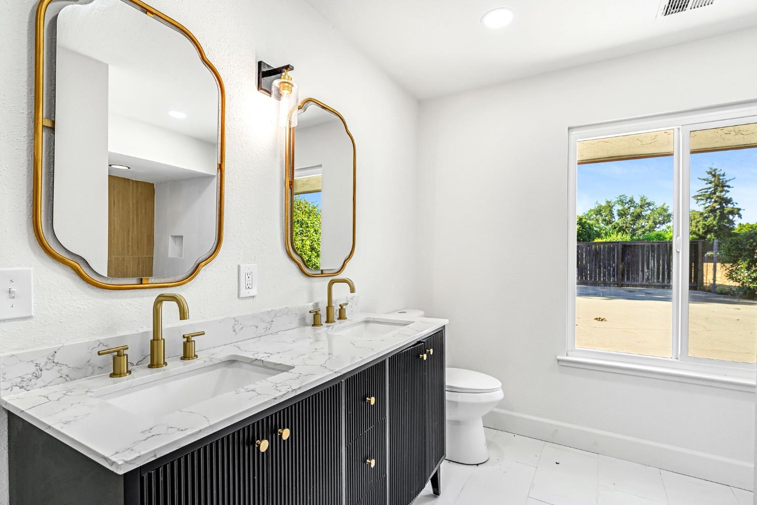 146 Sierra Avenue Clovis, CA 93612 - Photo 26 of 45 a bathroom with a granite countertop sink a large mirror and a toilet