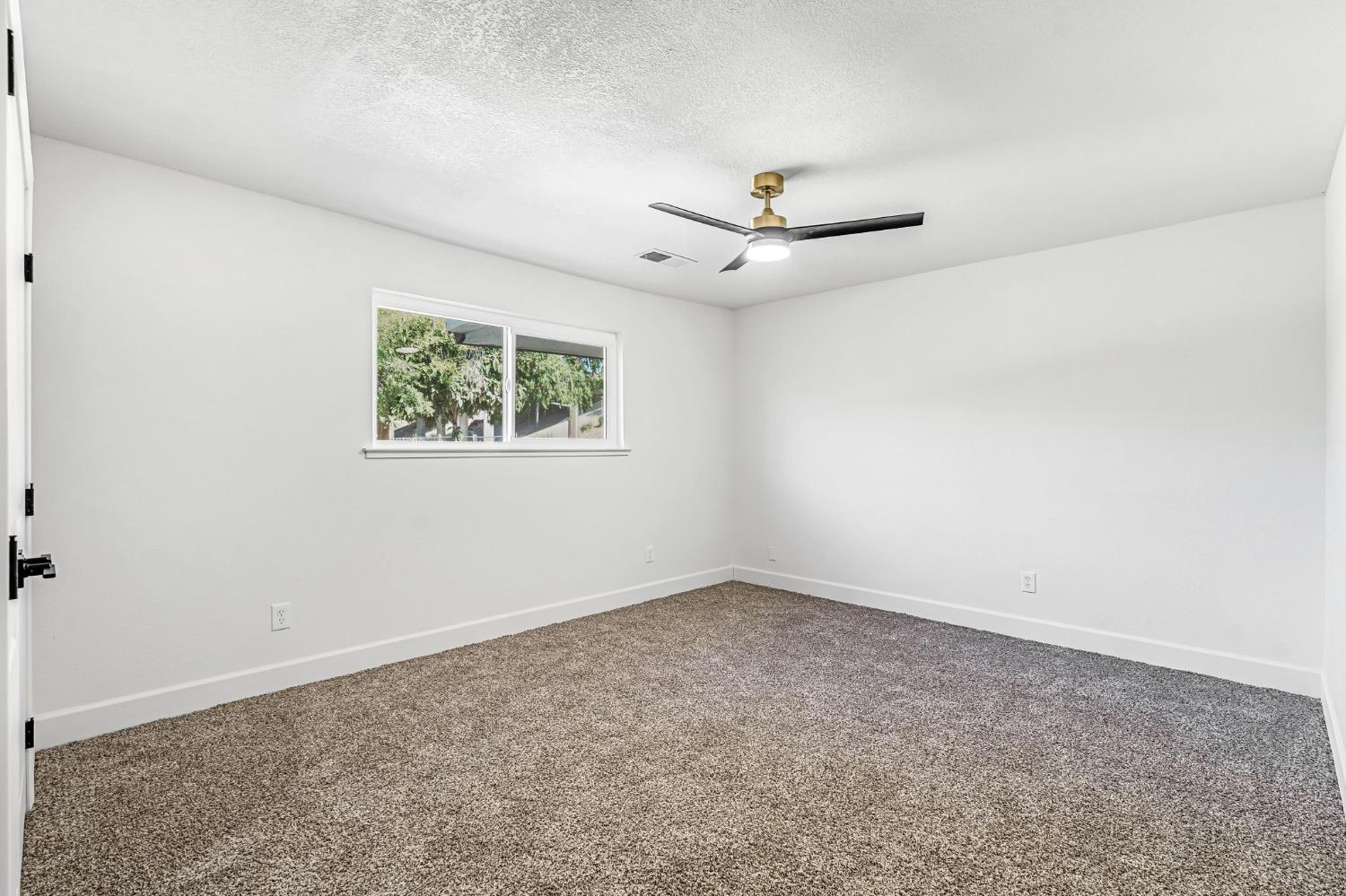 146 Sierra Avenue Clovis, CA 93612 - Photo 31 of 45 an empty room with a window and a ceiling fan