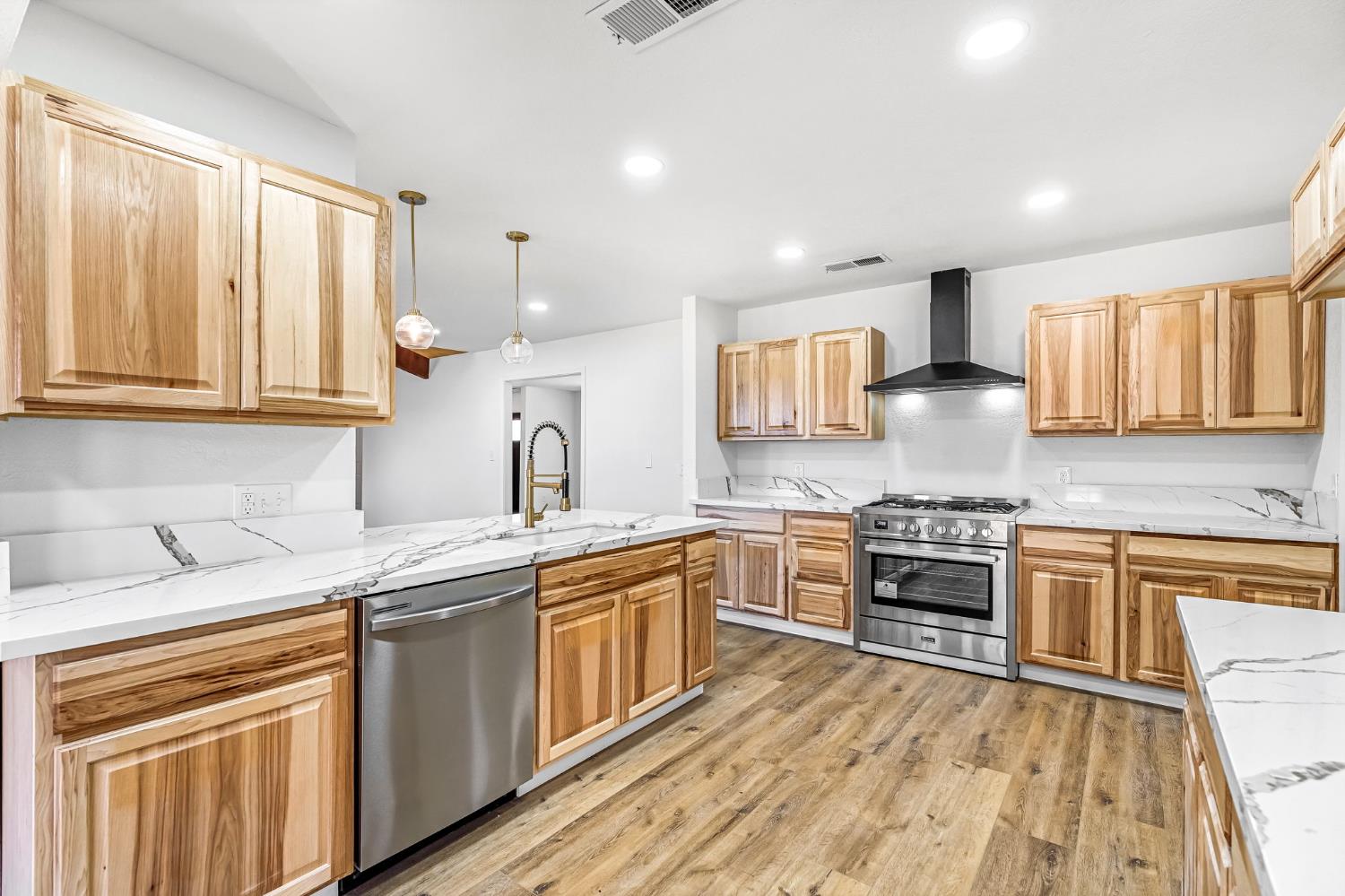 146 Sierra Avenue Clovis, CA 93612 - Photo 5 of 45 a kitchen with stainless steel appliances granite countertop wooden cabinets stove top oven and sink