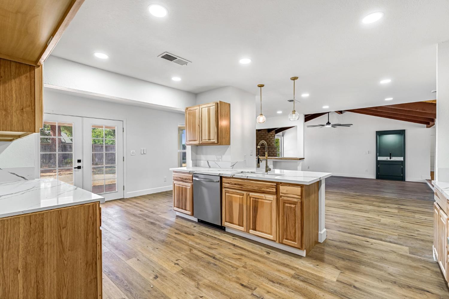 146 Sierra Avenue Clovis, CA 93612 - Photo 8 of 45 a large kitchen with stainless steel appliances granite countertop a sink dishwasher a stove and a refrigerator with wooden floor