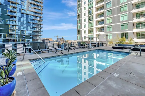 a swimming pool with outdoor seating and plants