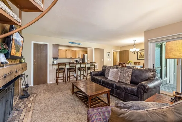 a living room with furniture and a kitchen view