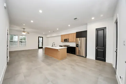 a large kitchen with stainless steel appliances kitchen island a large counter top and a sink