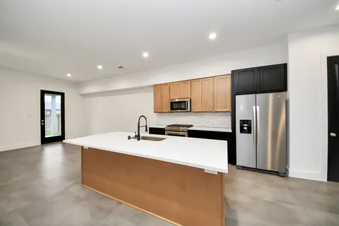 a kitchen with stainless steel appliances a refrigerator sink and microwave