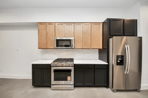 a kitchen with stainless steel appliances granite countertop a stove a refrigerator and a microwave