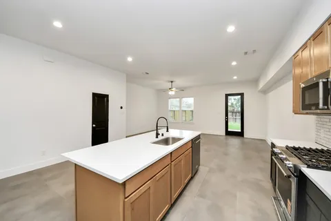 a kitchen with granite countertop a sink stove and cabinets