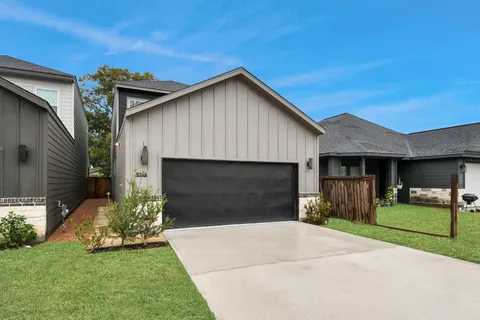 a front view of a house with a garden and yard