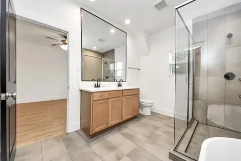 a spacious bathroom with a double vanity sink mirror and toilet