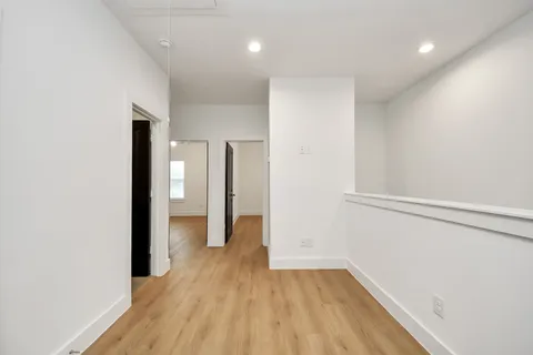 a view of a hallway with wooden floor