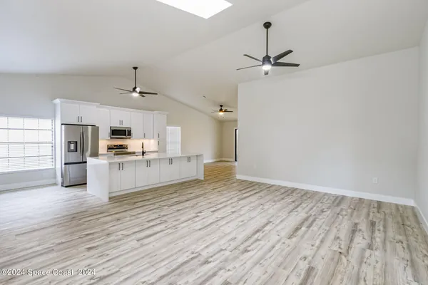 a view of kitchen with sink microwave refrigerator and cabinets