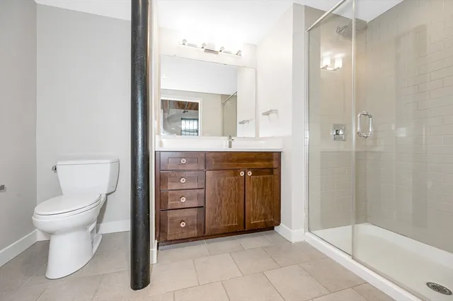 a bathroom with a toilet sink vanity and shower