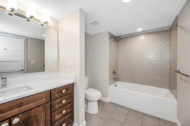a bathroom with a granite countertop sink a toilet and shower