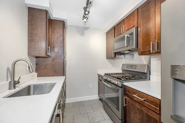 a kitchen with stainless steel appliances granite countertop a sink stove and refrigerator