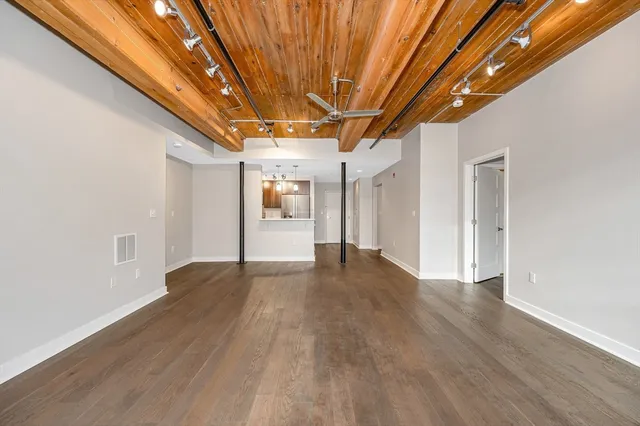 a view of empty room with wooden floor