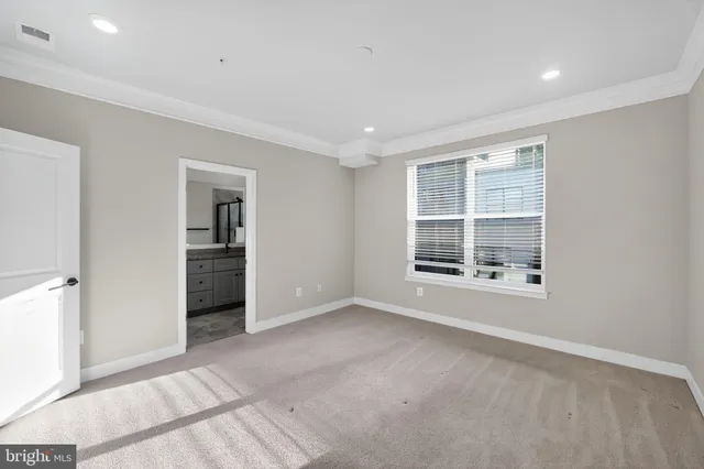 an empty room with windows and cabinet