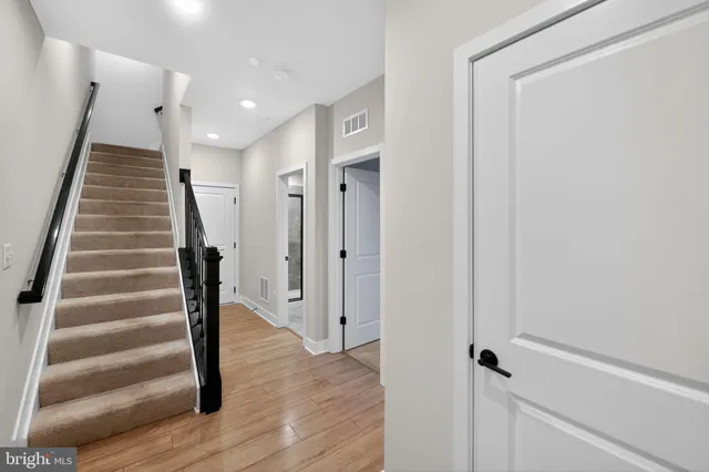 a view of a hallway with wooden floor and entryway