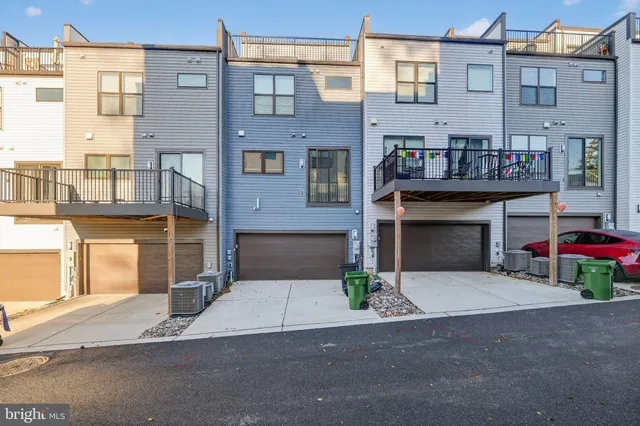 a front view of a building with garage and parking
