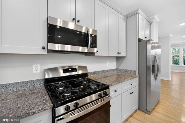 a kitchen with stainless steel appliances granite countertop a stove and a microwave