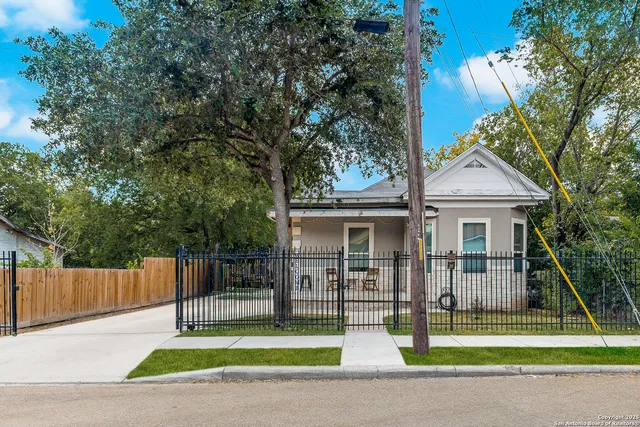a front view of a house with a garden and trees