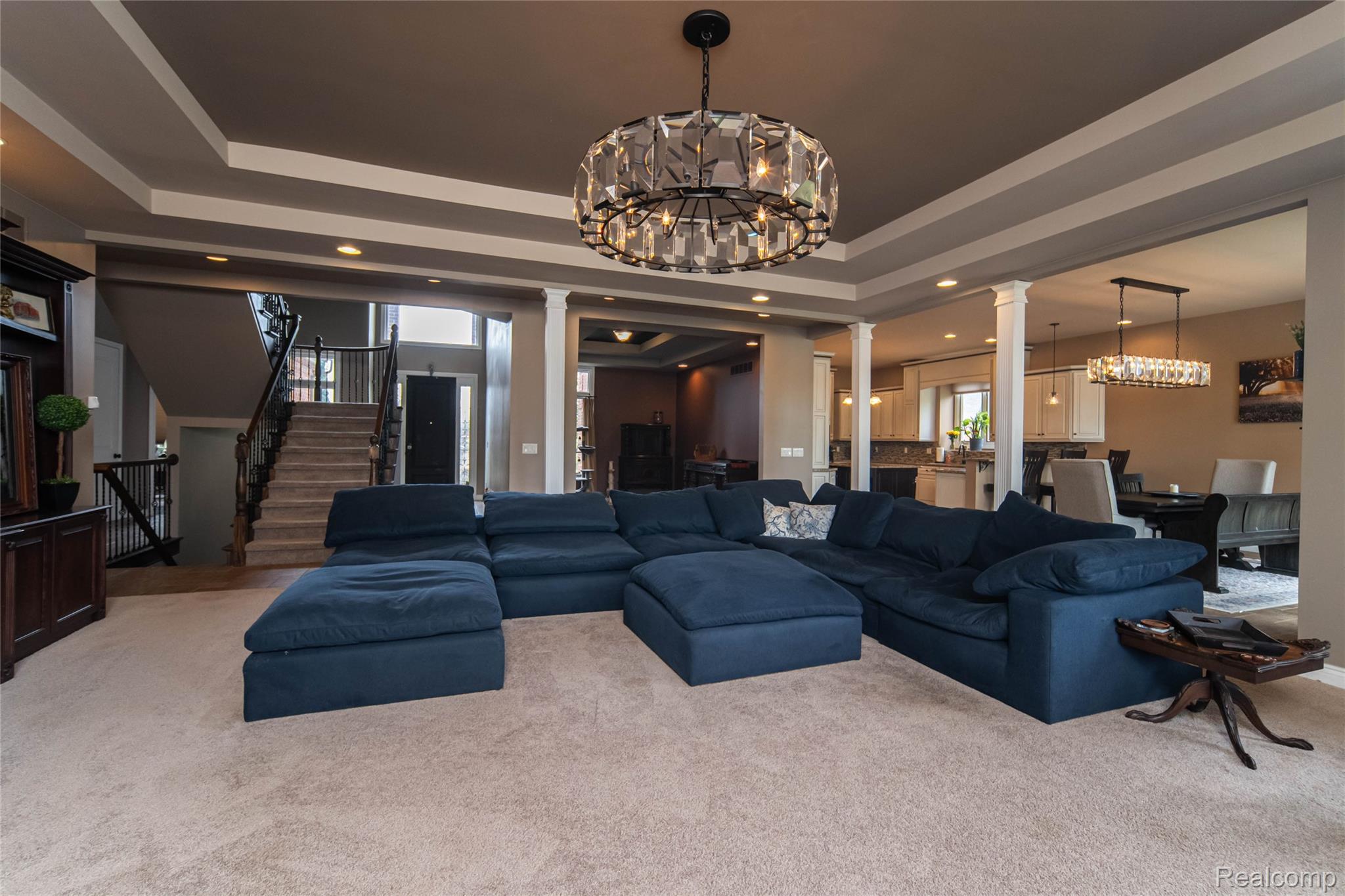67102 Rachael Lane Washington, MI 48095 - Photo 12 of 37 Living area with hanging lights, ornate columns, carpet floors, and a raised ceiling