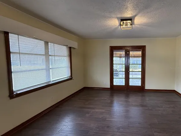 an empty room with wooden floor and windows