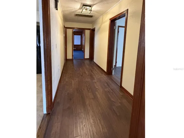 a view of a hallway with wooden floor