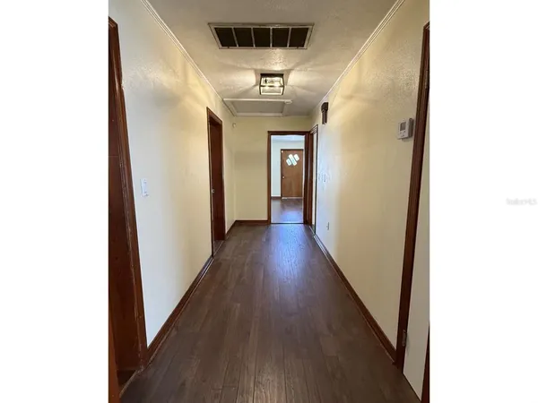 a view of a hallway with wooden floor