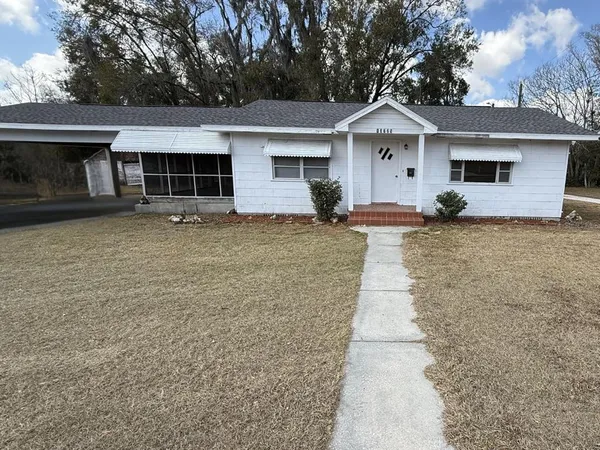a front view of a house with a garden and yard